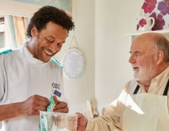 A nurse talking to an elderly nursing home resident - Maven Healthcare