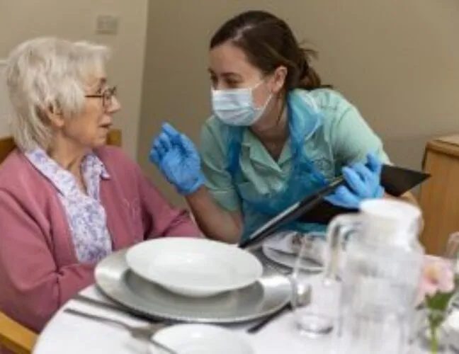 A nurse speaking to a resident - Maven Healthcare