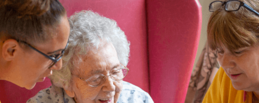 An elderly lady reading in a care home - Maven Healthcare