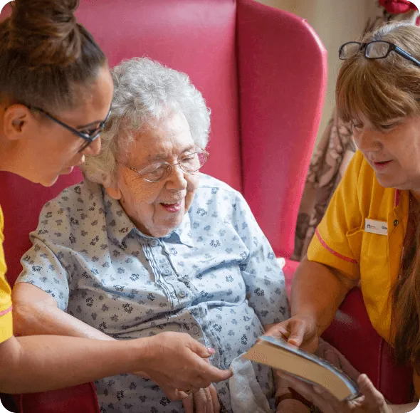 An elderly lady reading in a care home - Maven Healthcare