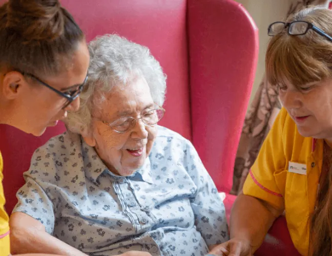 An elderly lady reading in a care home - Maven Healthcare