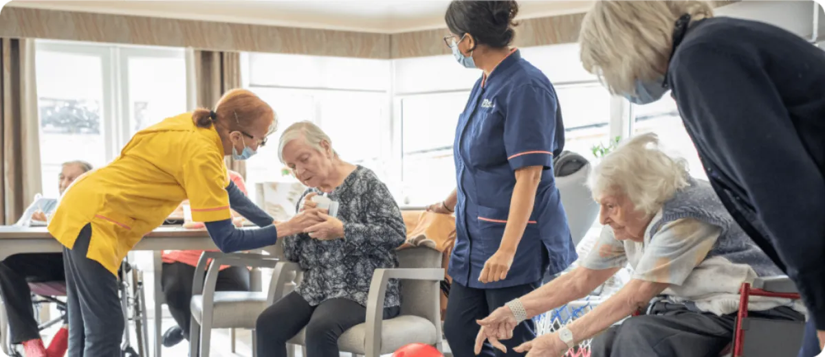 Nurses caring for elderly patients in the common room - Maven Healthcare