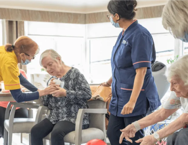 Nurses caring for elderly patients in the common room - Maven Healthcare