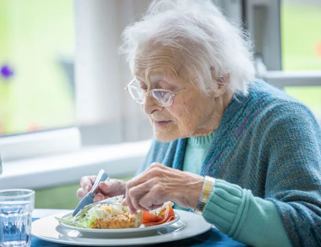 Elderly lady eating breakfast at St Oswalds care home - Maven Healthcare