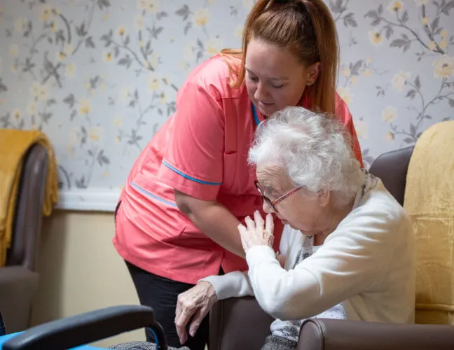 Nurse helping resident with mobility issues at St Oswalds House care home - Maven Healthcare